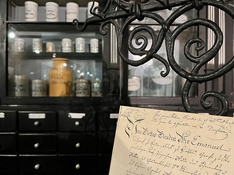 old pharmacy with jars in a glass cabinet and sign with old handwriting