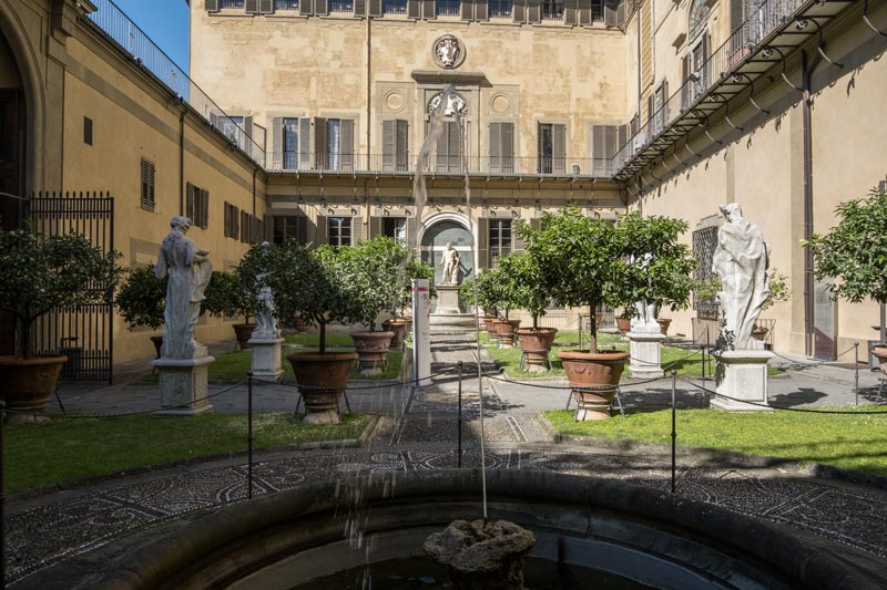 small pretty courtyard garden with fountain and statues