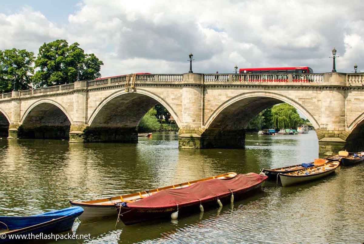 rowboats moored at side of river with bridge in background