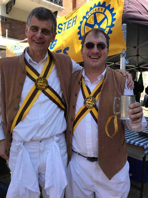 two morris dancers holding tankards of beer