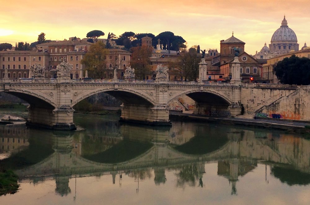 ornate bridge across river at dusk in rone which is the setting for many great italy movies