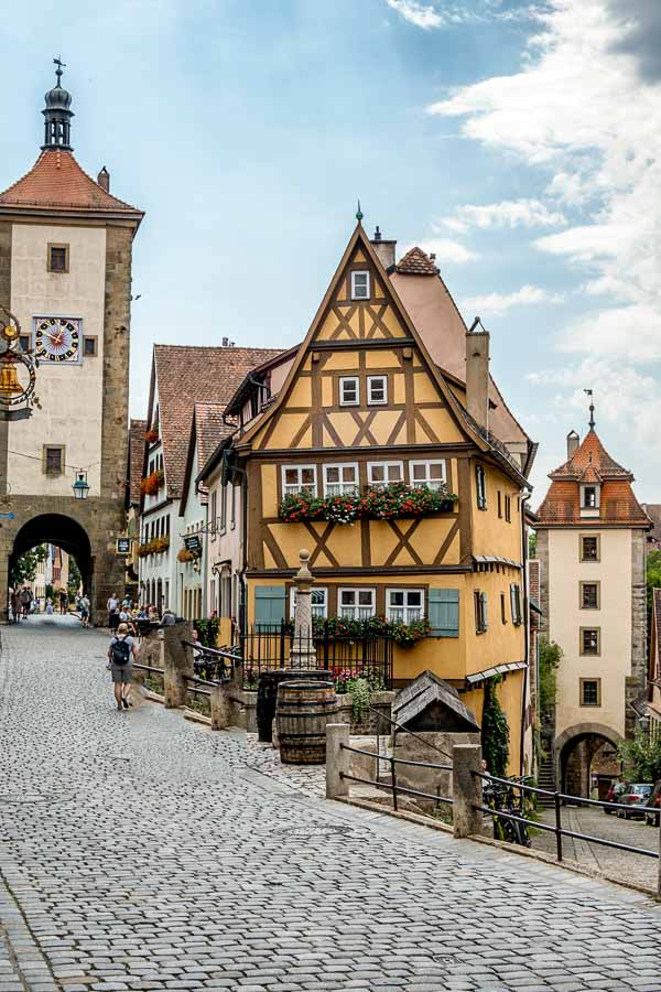 a half-timbered house flanked by 2 tpwers