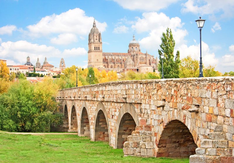 sandstone bridge leading to a cathedral in the beautiful spanish city of salamanca