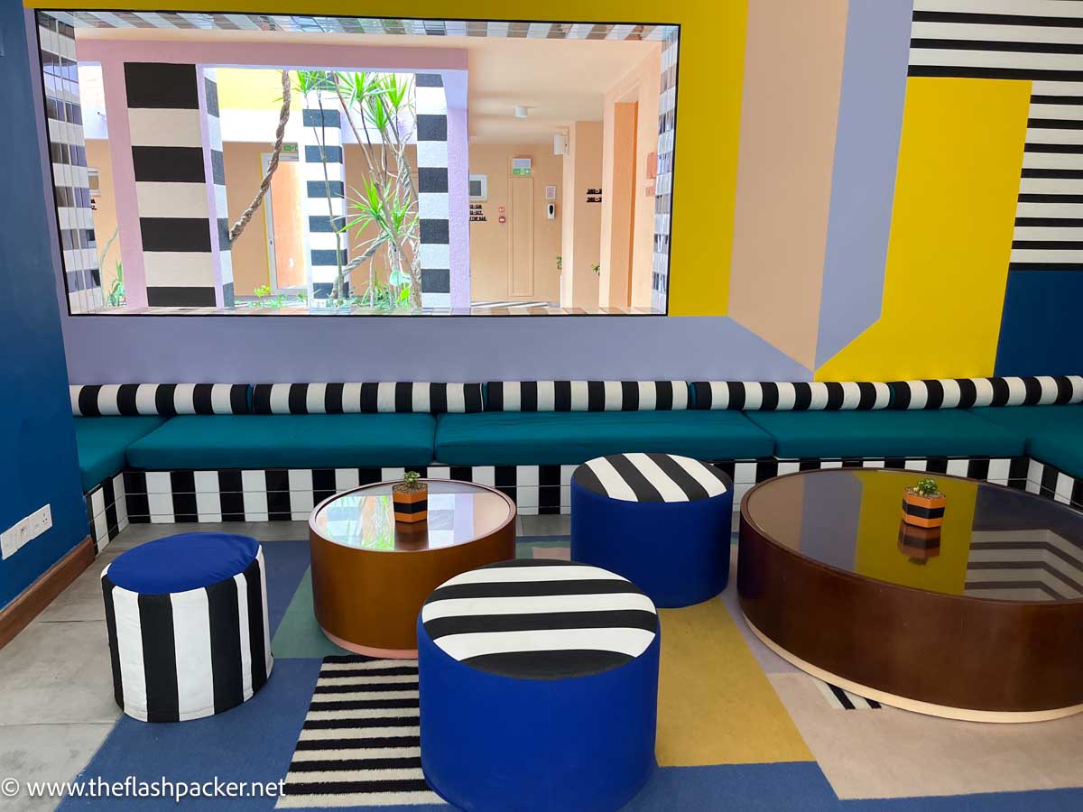 reception area at hotel with sofas and soft stools in bright geometric patterns