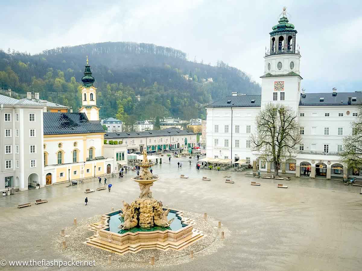 pretty square in salzburg with white and yellow stucco buildings and central fountain