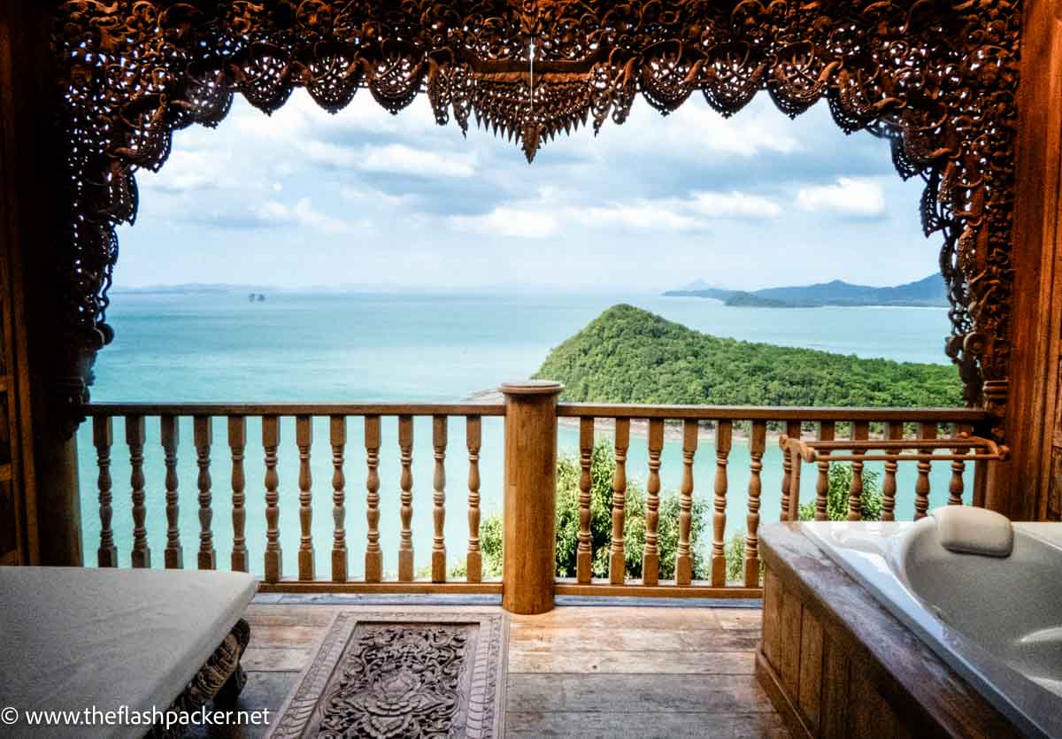 carved wooden hotel balcony looking over sea and island