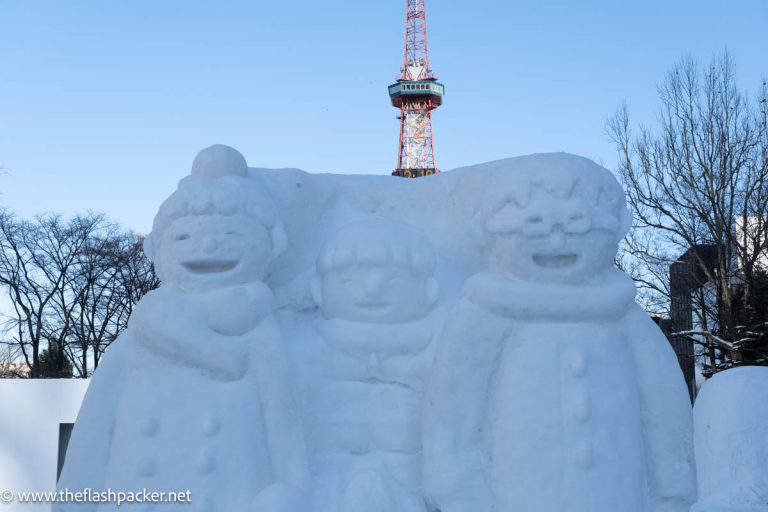 large snow sculpture of three anime characters