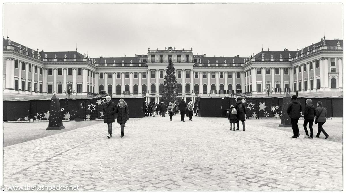 people walking in courtyard in front of palace building in vienna