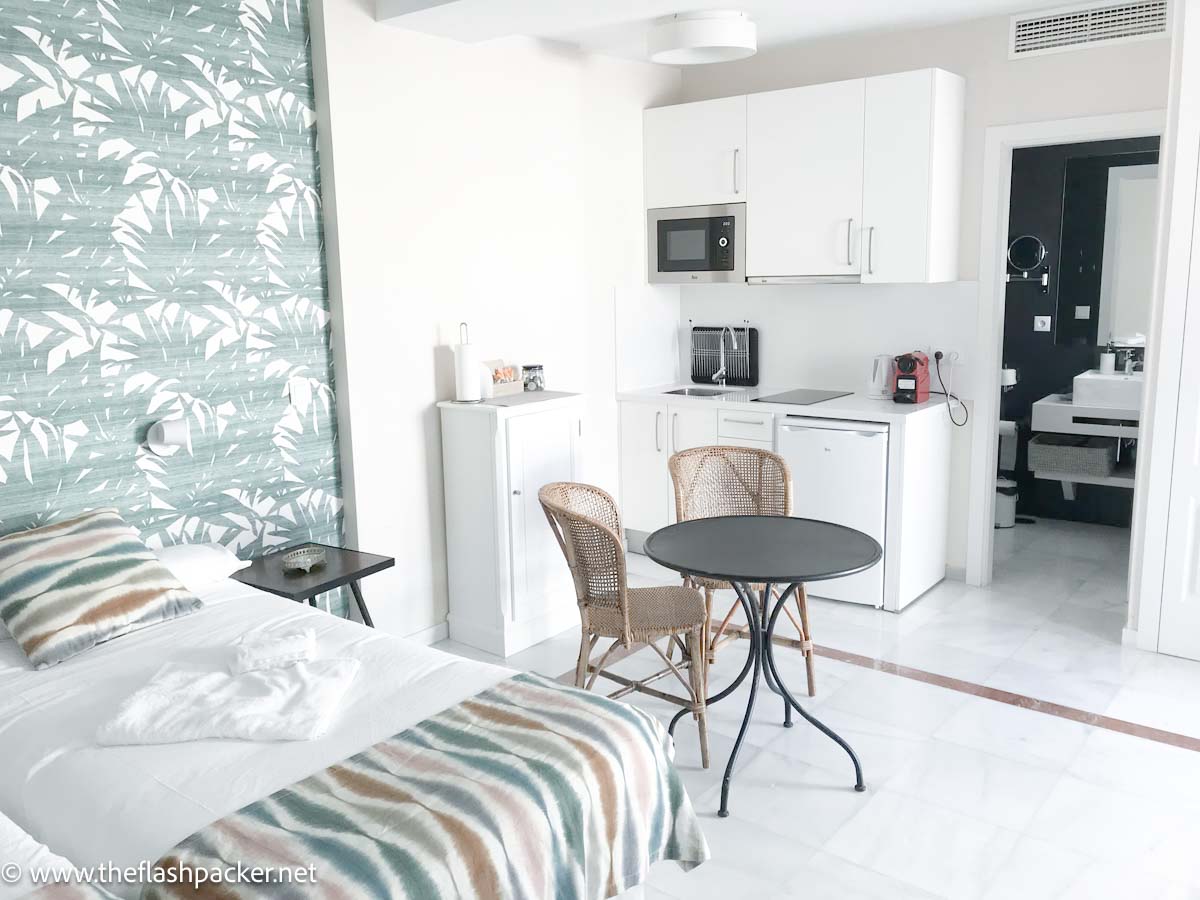 studio apartment with bed table and chairs and kitchenette