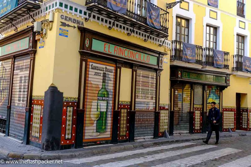 man walking past shuttered bar called el rinconcillo