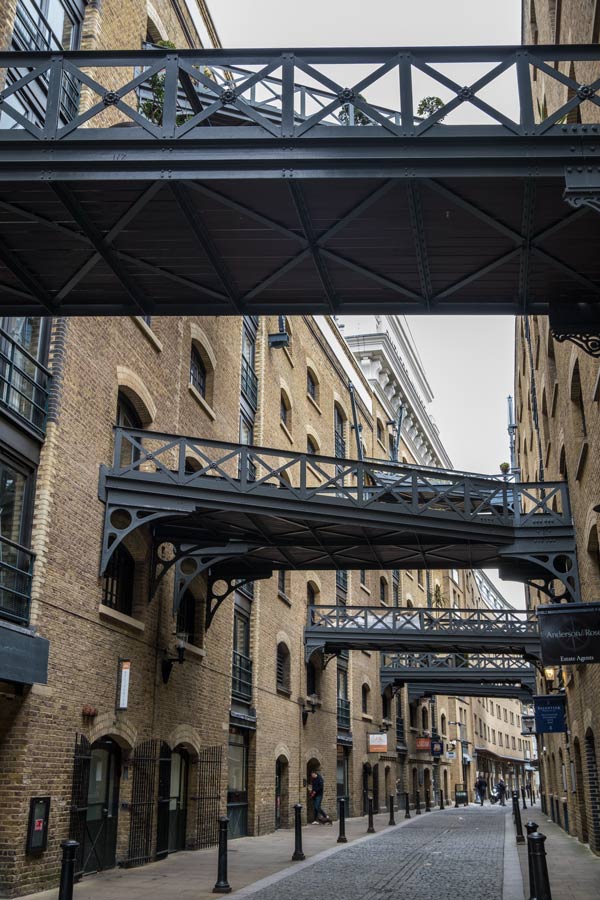 street lined with old warehouses linked by iron gantries