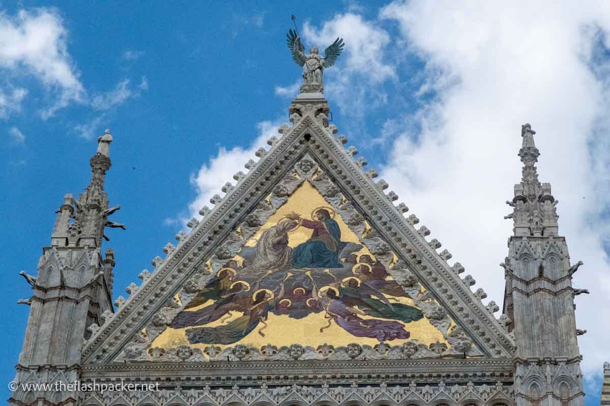 golden mosaic of jesus crowning mary between 2 spires of siena cathedral