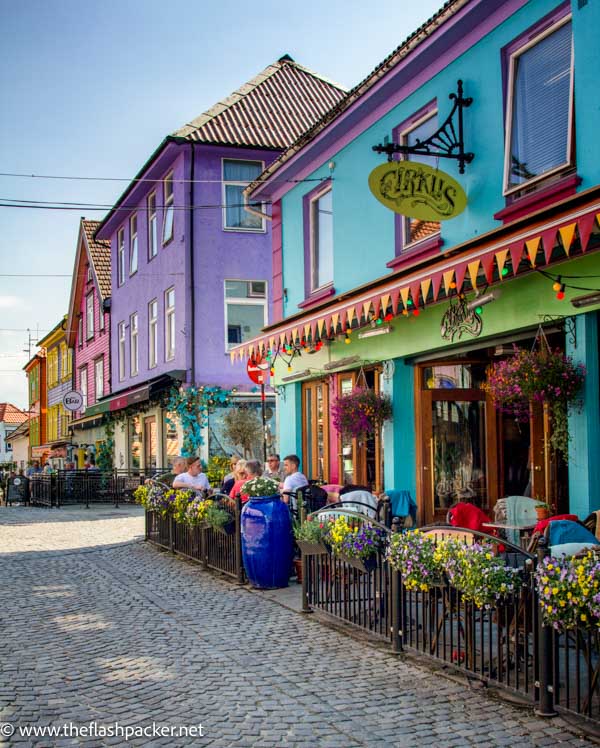 group of people having a coffee outside brightly coloured buildings in skagen stavanger