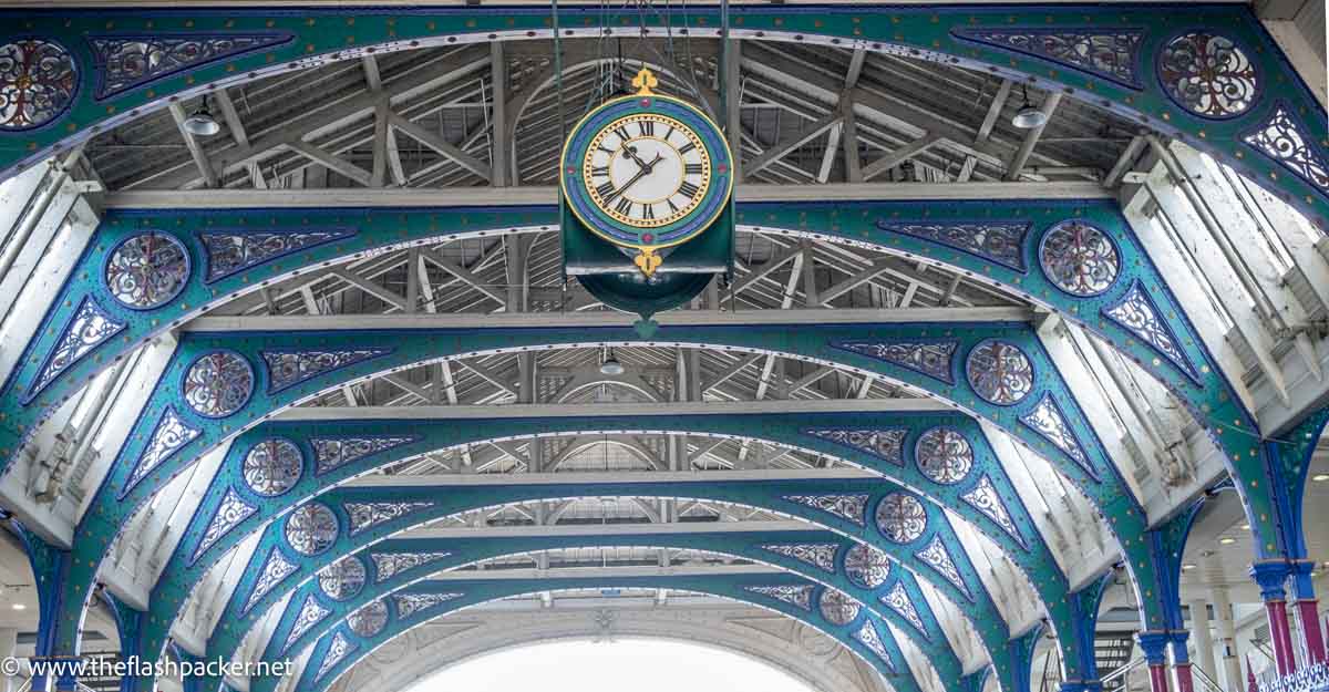 blue and grey wrought iron roof with old clock