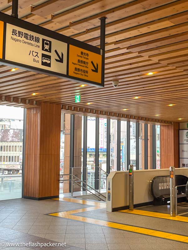 signs inside nagano railway station pointing to bus