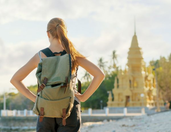 young woman looking at golden pagoda in asia