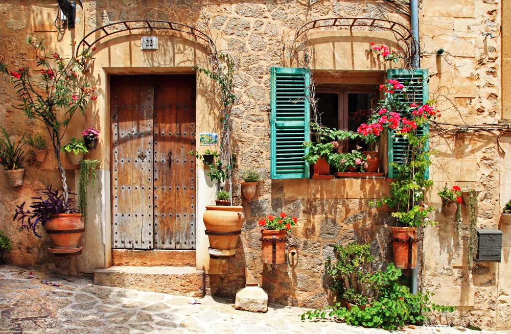 charming street in spain with flower pots and cobble stones