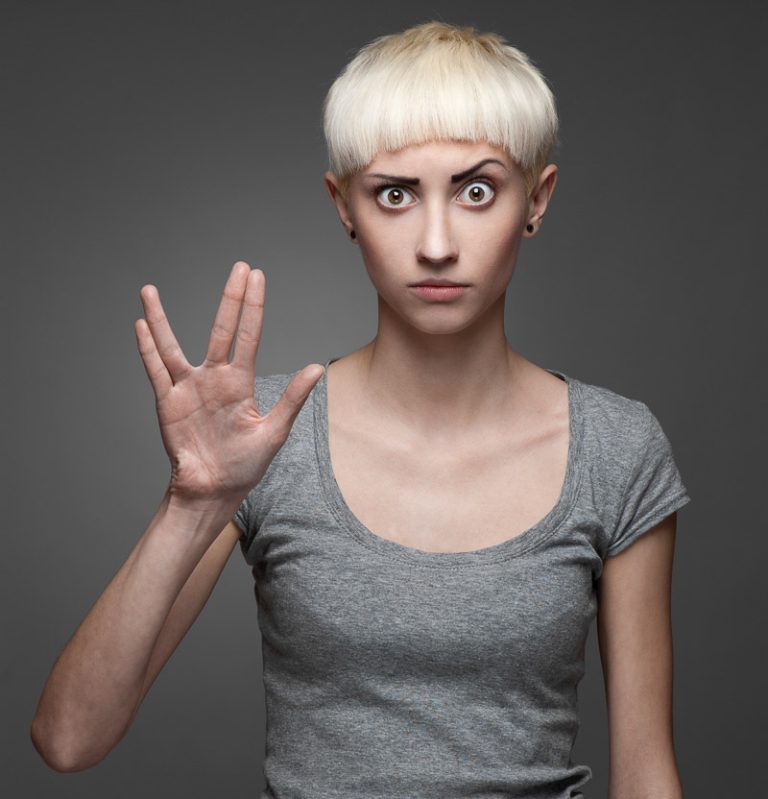 woman in a grey t short giving a vulcan salute to camera