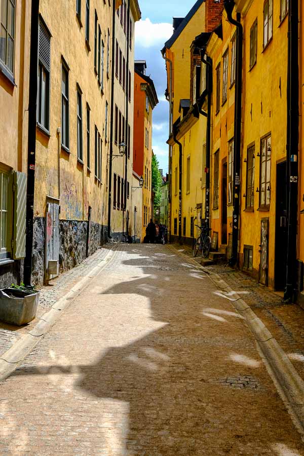 narrow cobblestone street lined with old ochre coloured buildings in stockholm old town