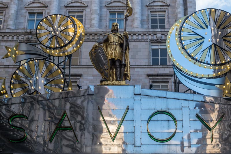 sign for the savoy in london with art deco sculptures