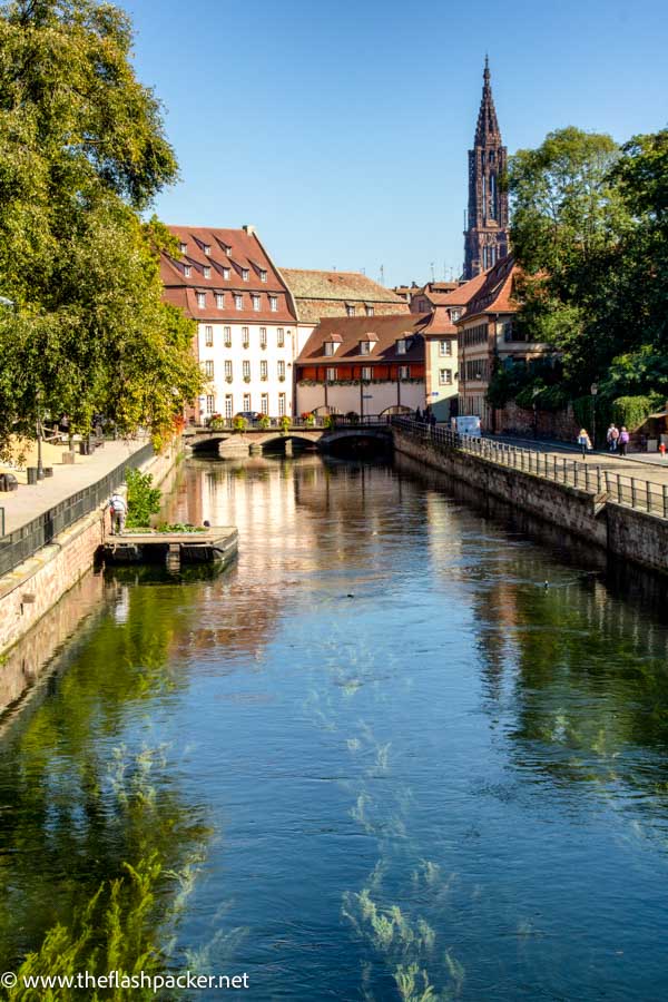 pretty canal in strasbourg with cathedral spire and bridge in background