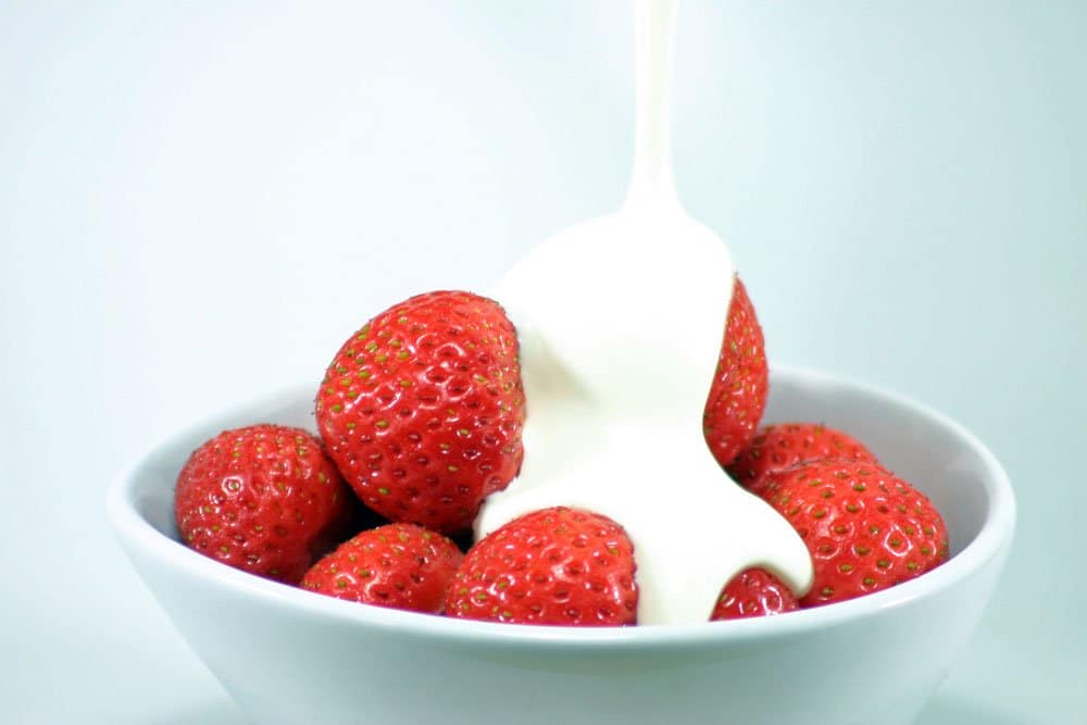 a bowl of strawberries and cream