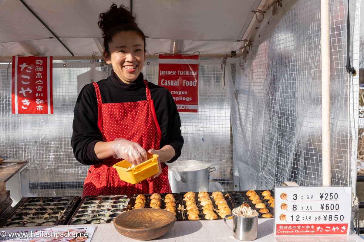 happy woman making dumplings at a food stall