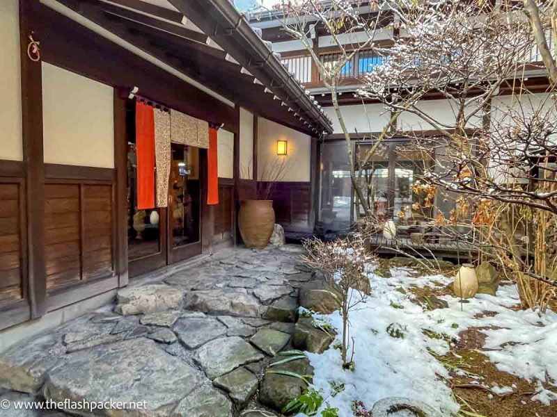 small garden and cobbled path outside traditional japanese building housing Oyado Koto No Yume ryoken