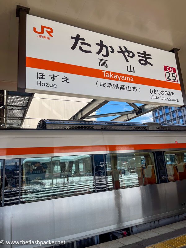 grey and red train at platform at takayama station