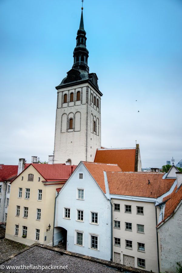 pastel coloured medieval buildings and church tower in tallinn