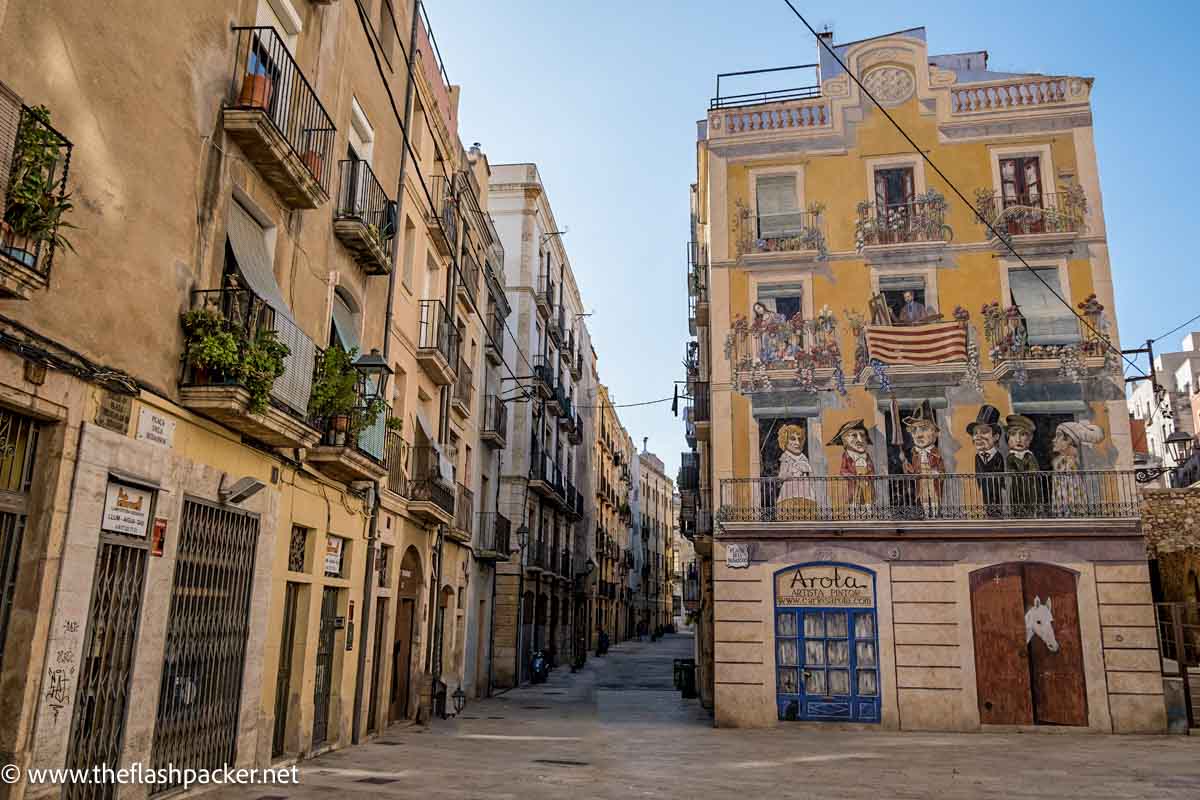 medieval street with plaza and central building painted with street art