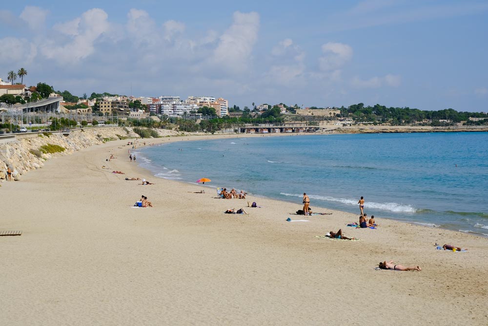 people relaxing on a broad sandy beach