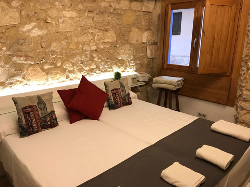 hotel bedroom with large bed and stone walls