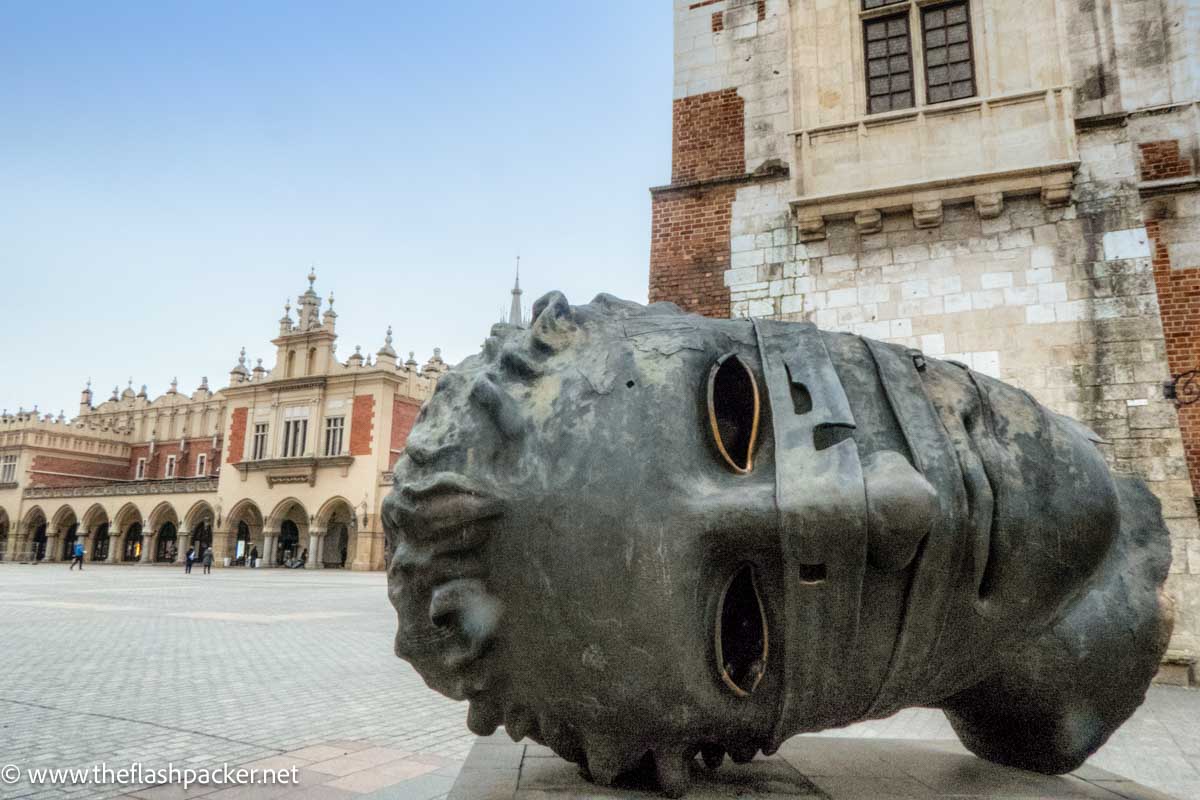 massive head sculpture in old square in krakow