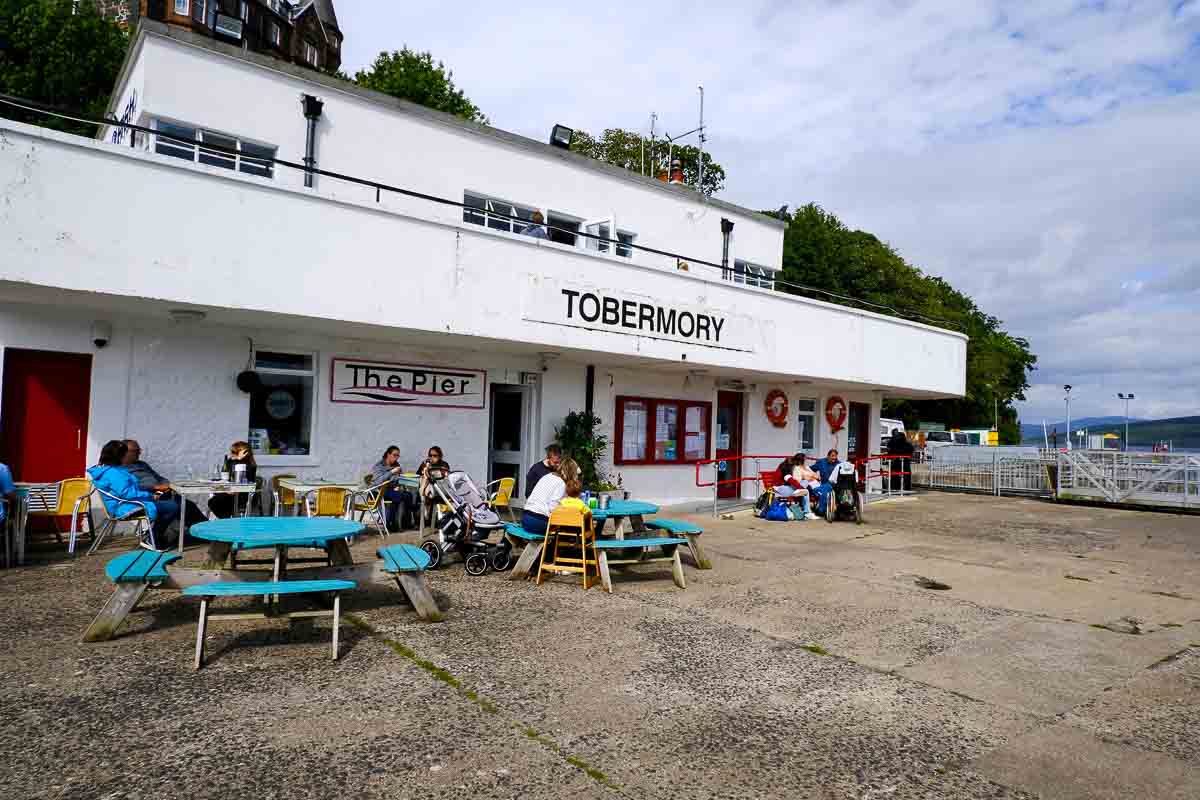 people sitting outside a restaurant in tobermory mull scotland