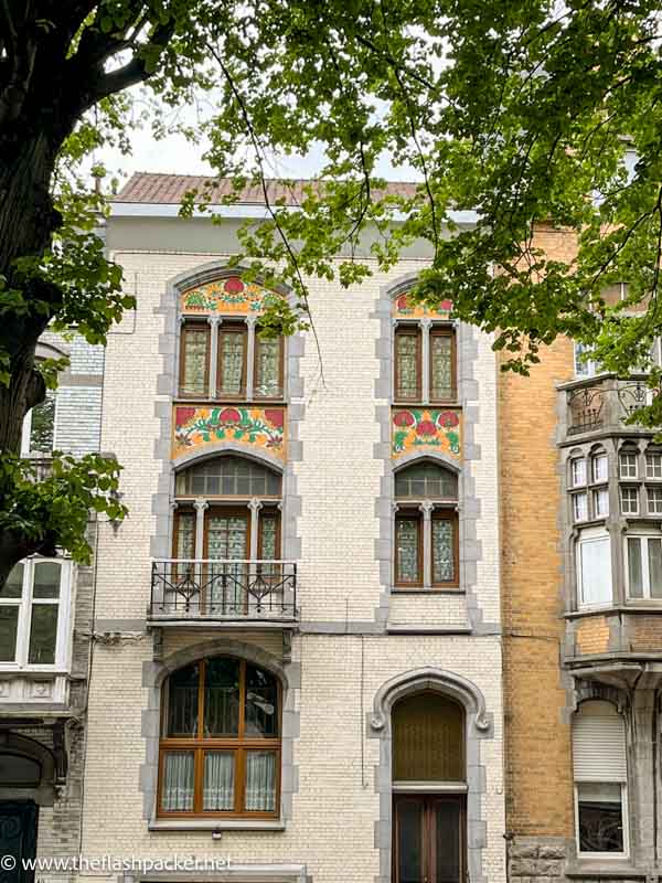 tall slim art nouveau house with iron balcony and painted exterior