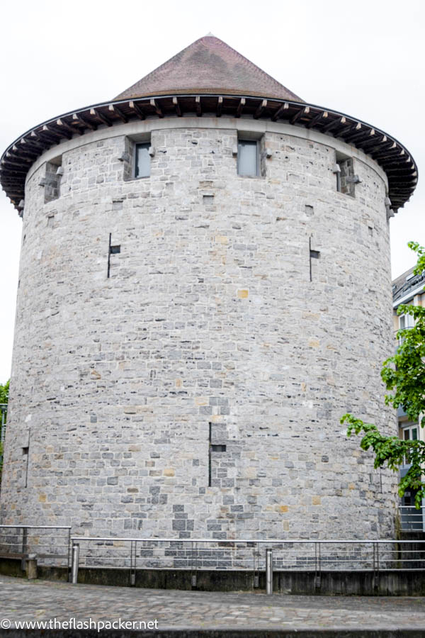 stone defensive tower with red tiled conical roof