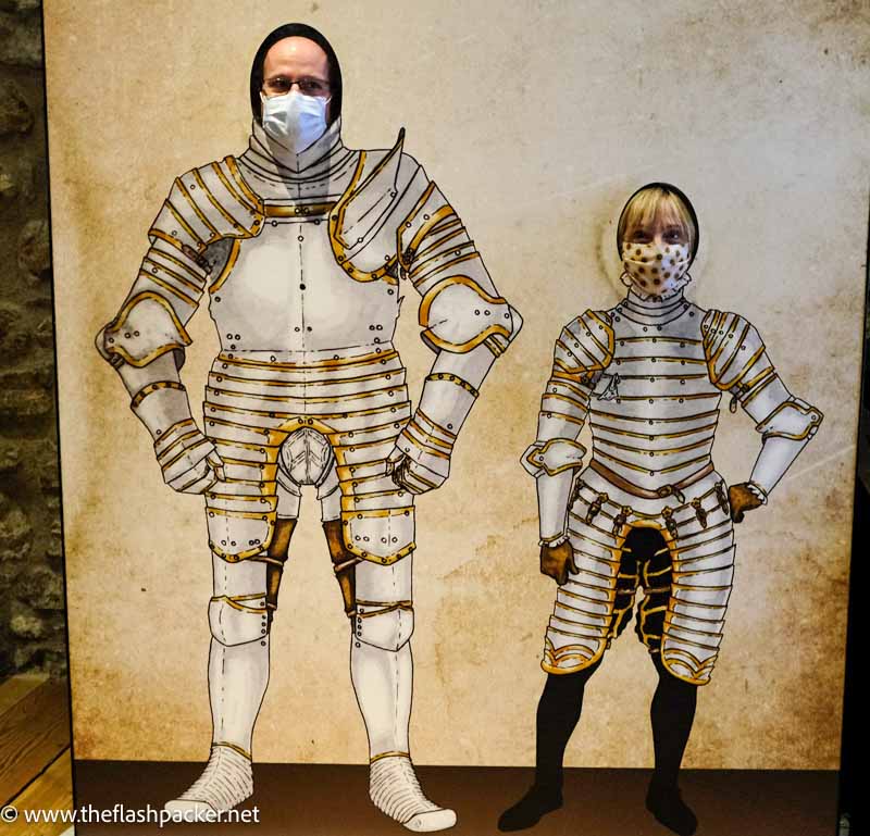 man and woman posing behind cut outs of soldiers in armour