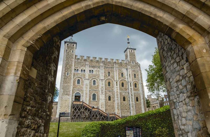 white tower at tower of london viewed through a stone arch