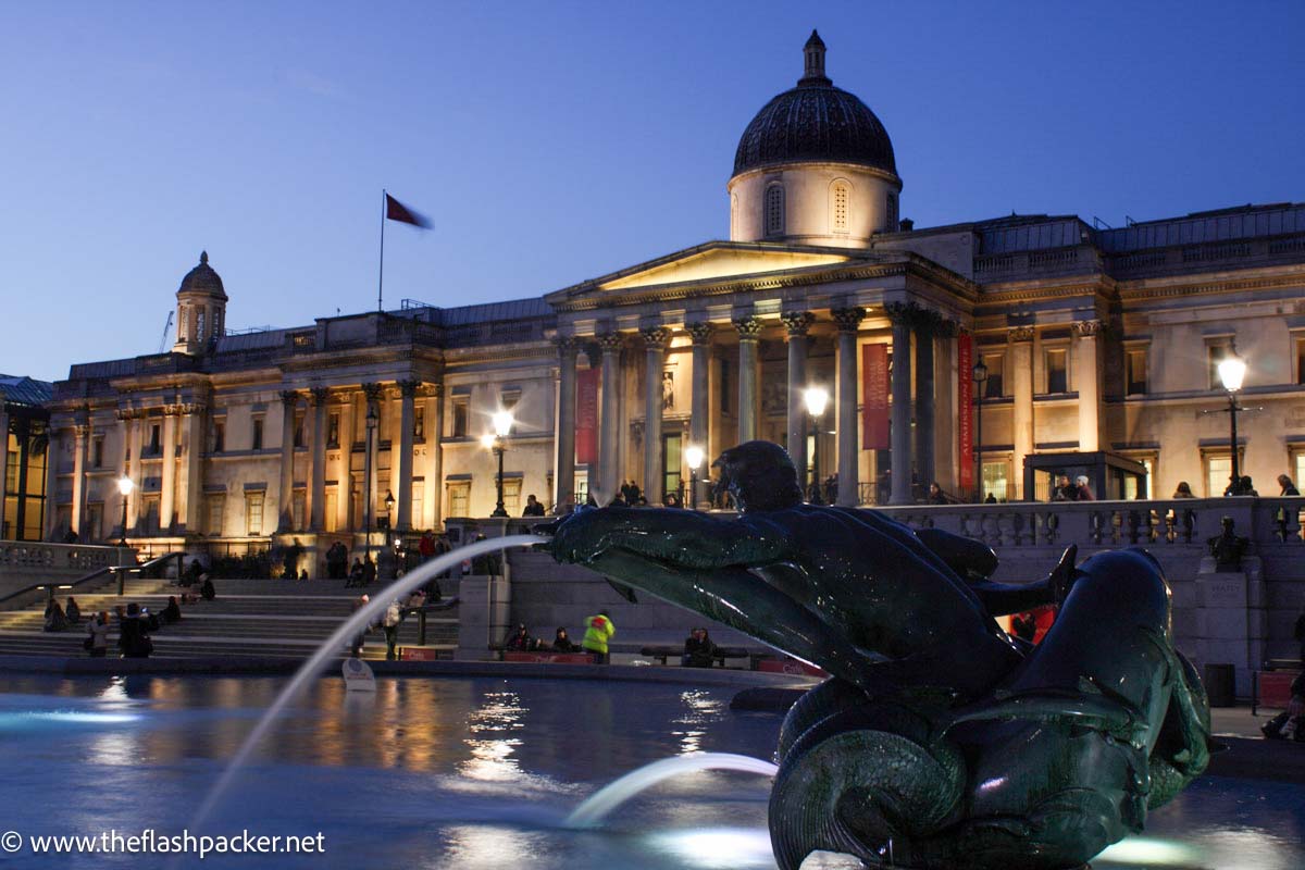 trafalgar square at night with fountain in foreground