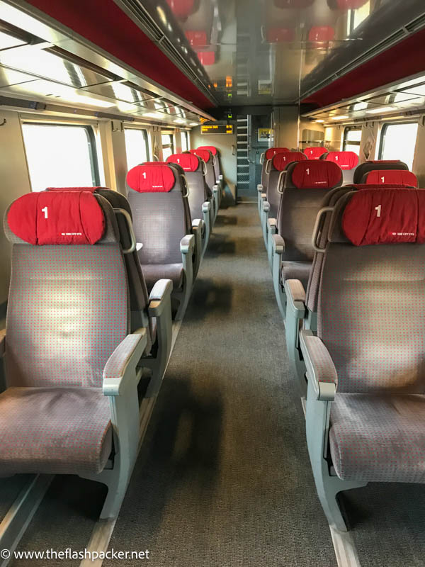 grey seats with red headrests inside a train carriage in switzerland