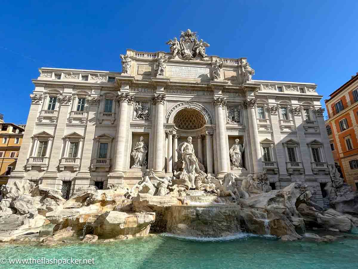 elaborate large fountain of trevi in rome italy in front of a colonnaded building