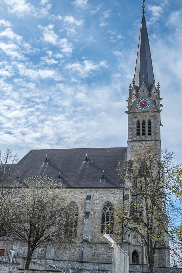 stone exterior of vaduz cathedral with tall bell tower