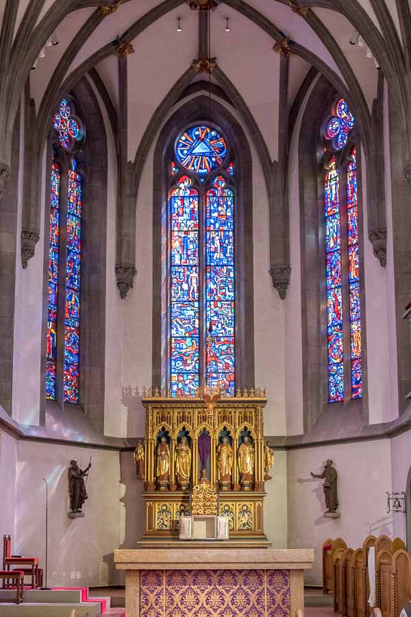 altar of vaduz cathedral with gilded tabernacle and stained glass windows