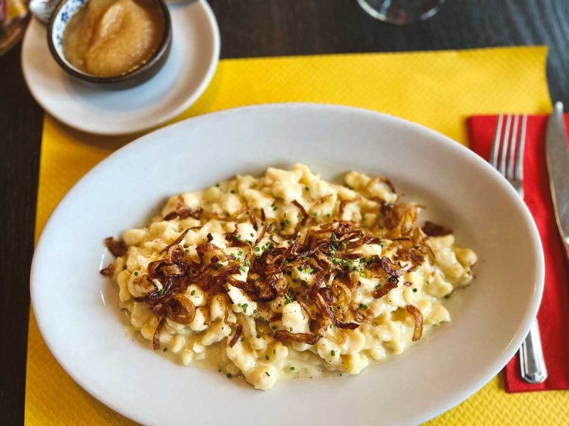 plate of macaroni type pasta with cheese sauce topped with onions