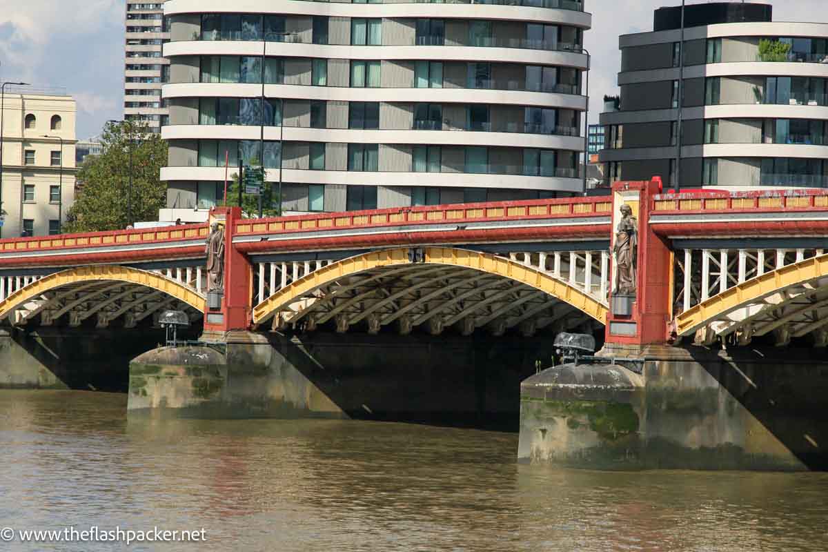 red and yellow river bridge in london studded with giant sculptures