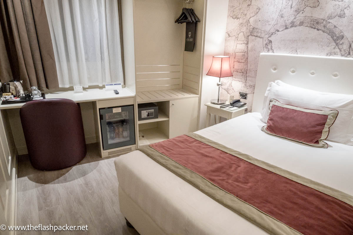 bedroom at hotel giberti verona with table and chair and bed with white linen