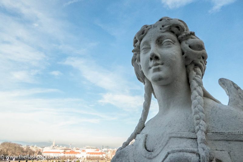 large statue of a woman in front of the skyline of vienna