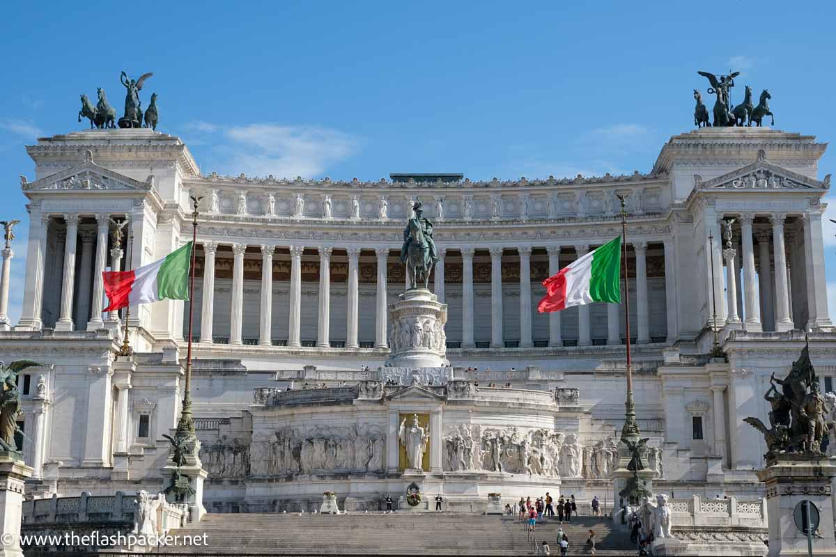 white monumental building in rome with classical columns and statues