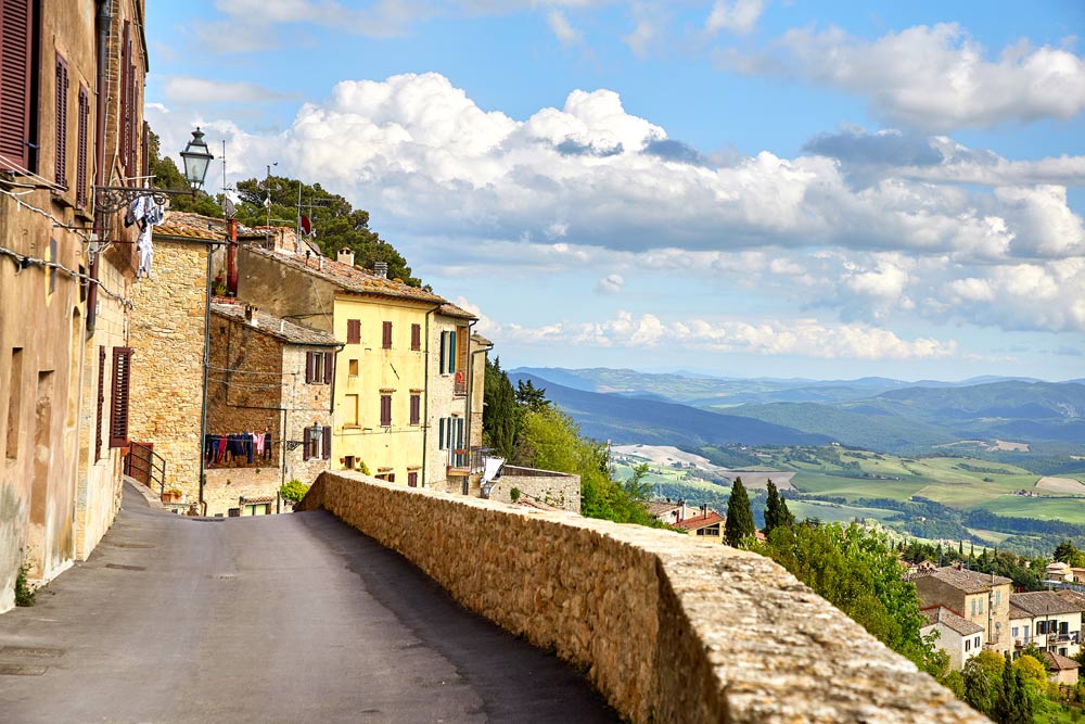 the edge of one of the beautiful small towns in tuscany overlooing the green landscape